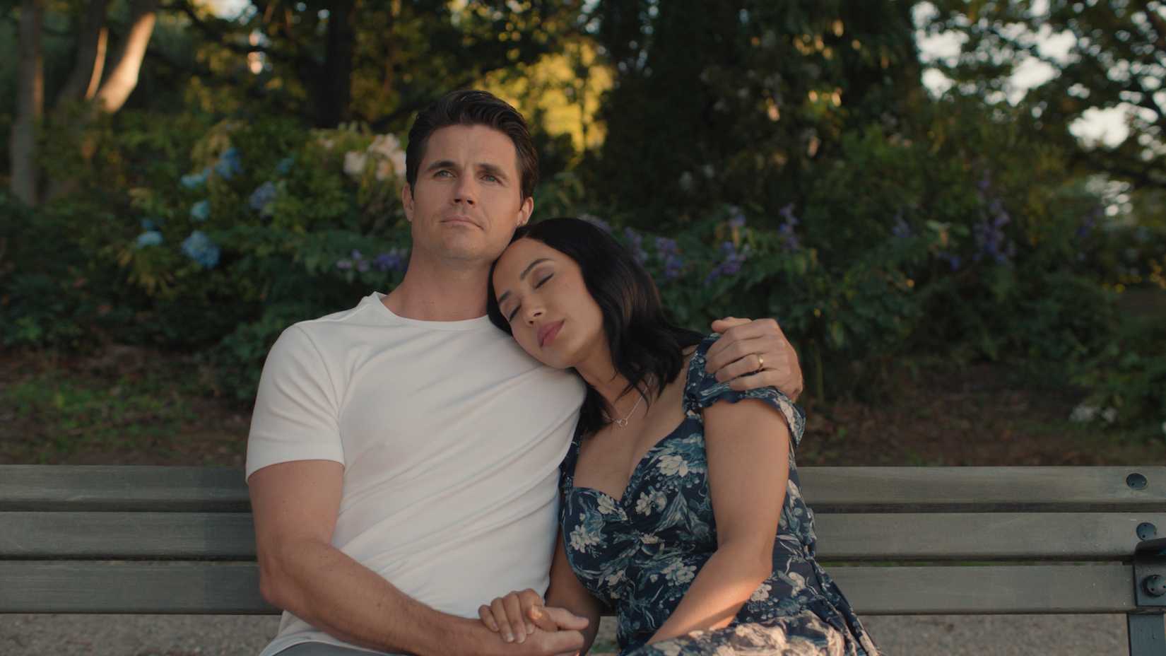 Robbie Amell and Andy All sitting together and holding hands in Upload